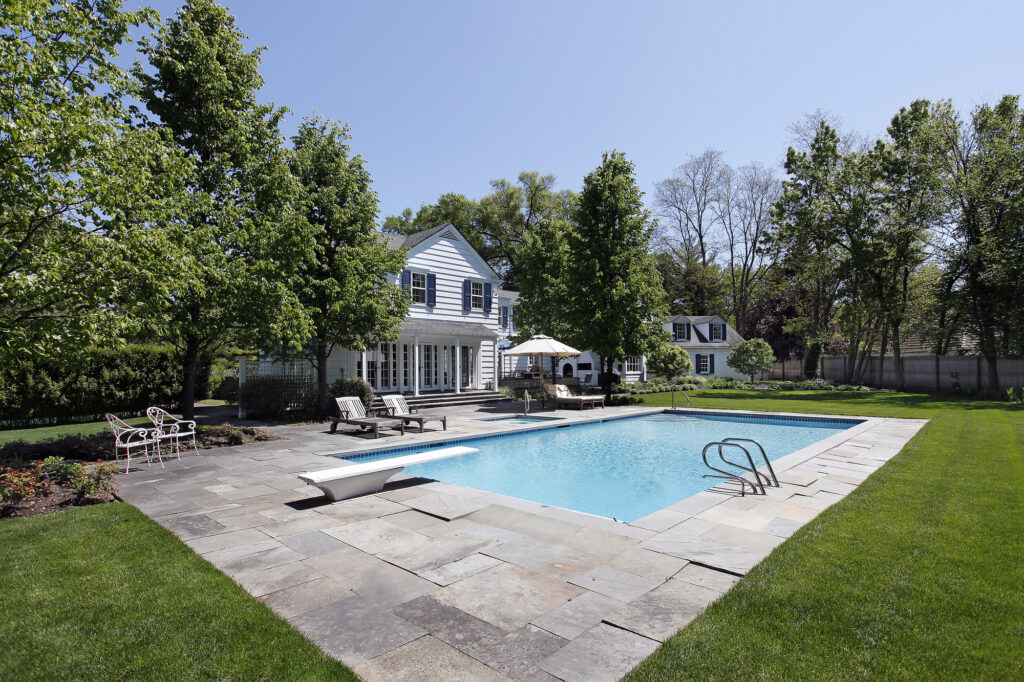 Use a pool loan to get a swimming pool outside luxury home with diving board