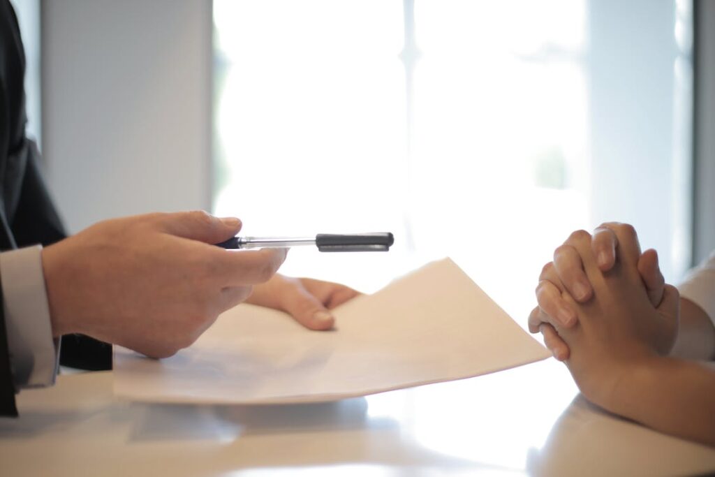 Insurance agent giving a contract to a woman to sign