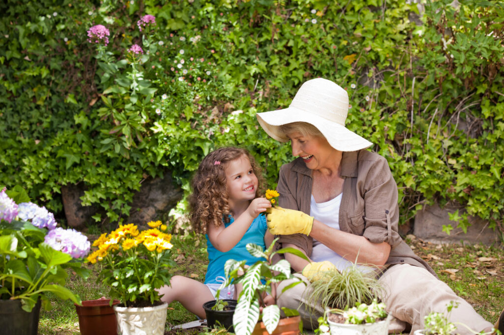 Happy Grandmother with her granddaughter working in the garden after reading free gardening catalogs