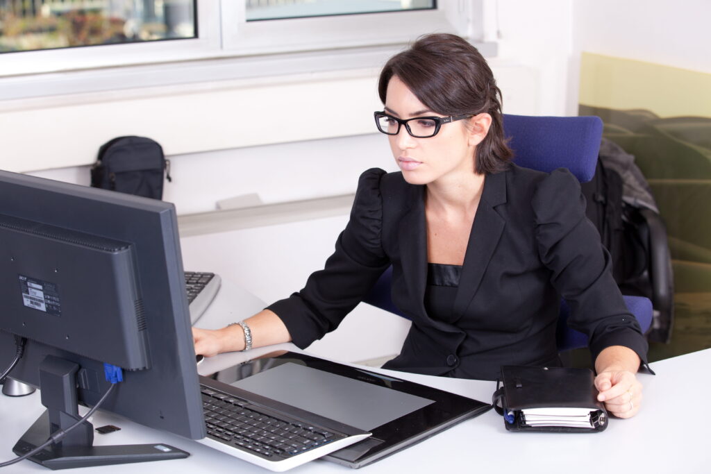 woman using computer wearing black blazer