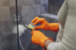 photo of woman cleaning shower for the article: 10 Effective Hard Water Removers: Say Goodbye to Stubborn Stains