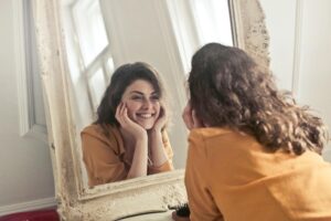 woman looking at herself in the mirror smiling