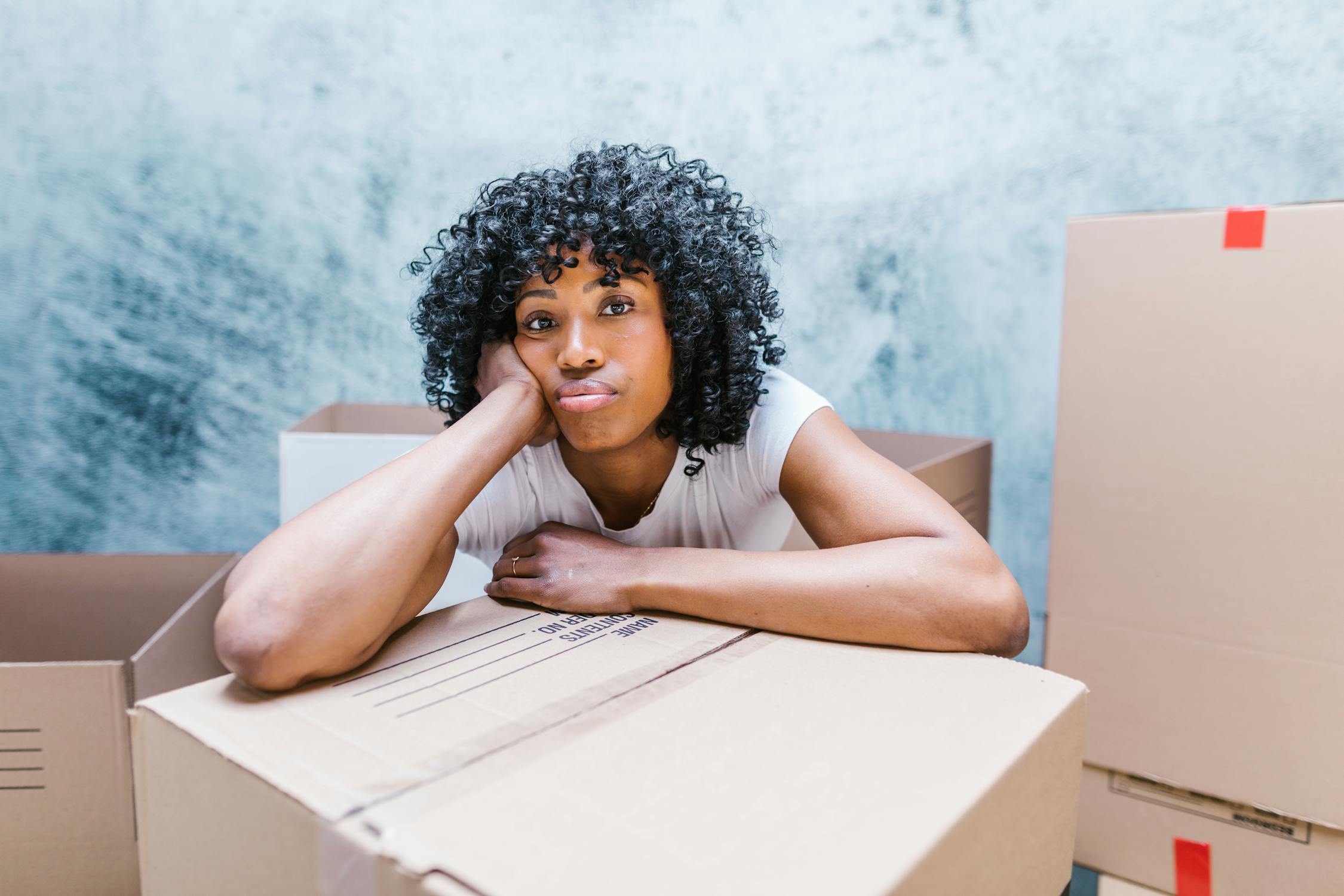 A woman leaning on a cardboard box