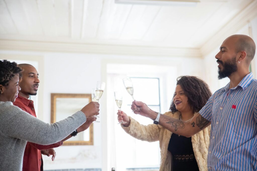 A group of friends raising glasses of champagne in a toast, celebrating together in a bright, welcoming room.