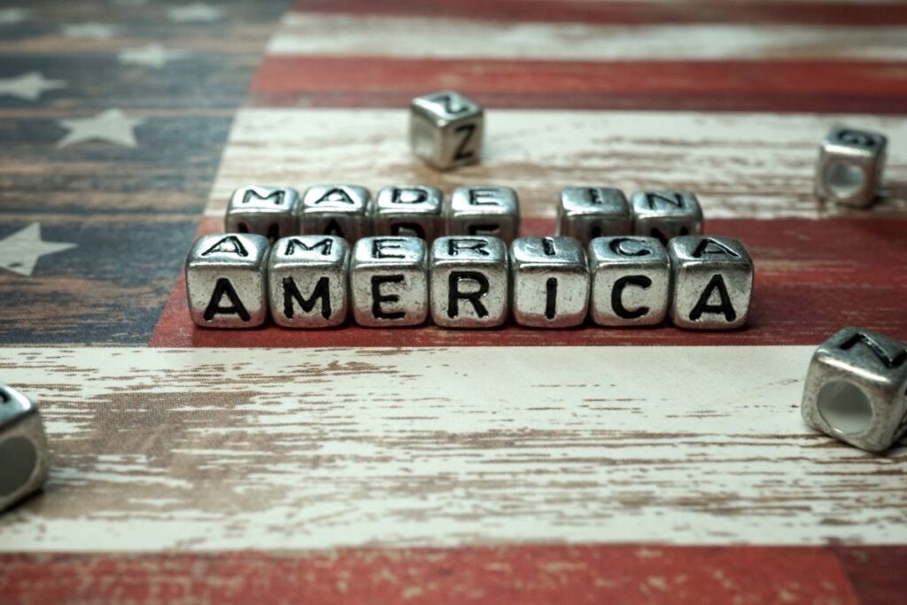 Metal letter beads spelling "Made in America" on a rustic American flag background.