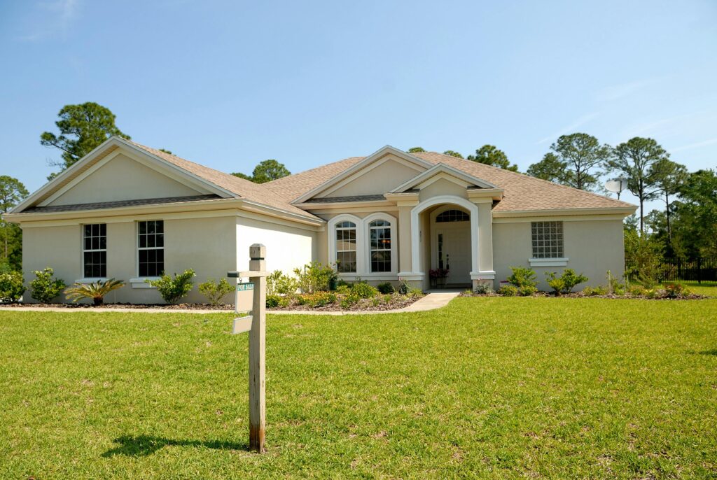 A house with a lawn and a sign.