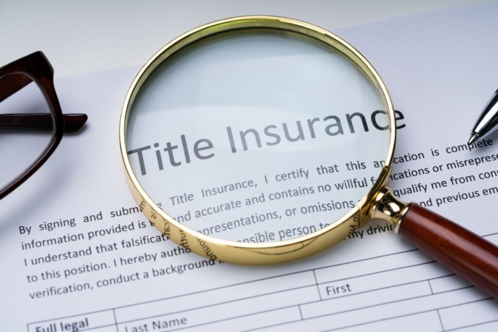 Magnifying glass focusing on the words "Title Insurance" on a legal document, symbolizing the scrutiny and protection title insurance provides for homeowners.