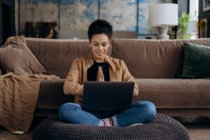 Woman smiling while shopping online from home with her laptop