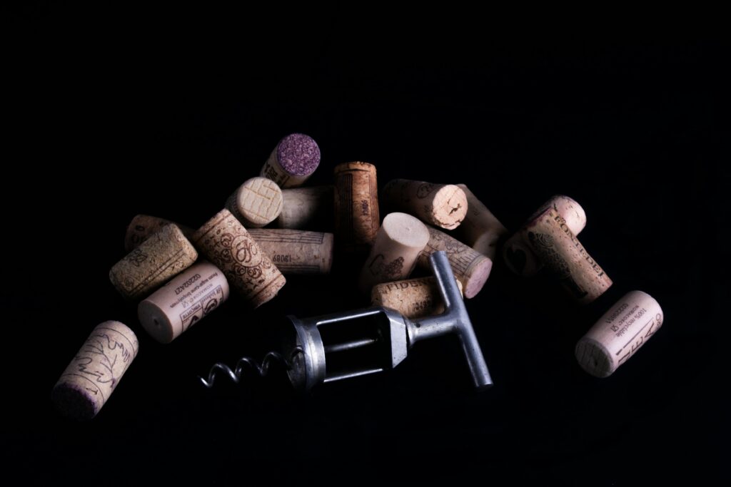 A collection of wine corks with a corkscrew on a dark background.