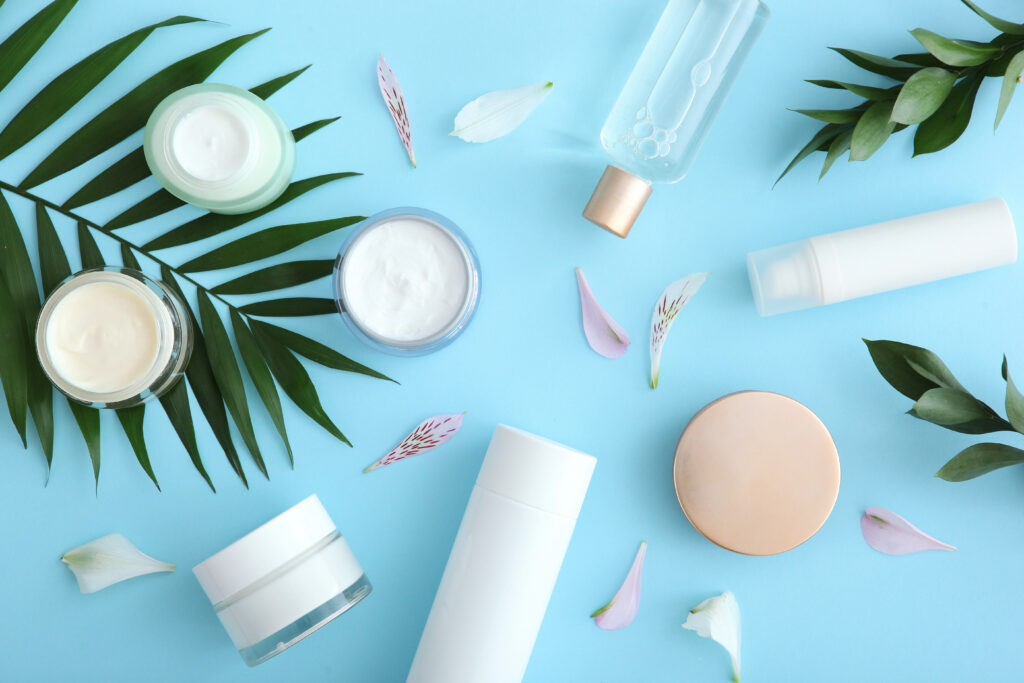 Flat lay of skin care products with creams, serums, and moisturizer jars on a blue background, representing skin care free trial offers