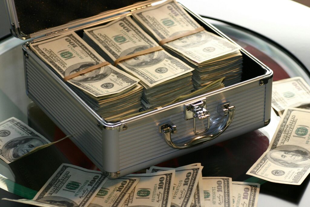 Metal briefcase filled with stacks of US hundred dollar bills representing wealth and smart money habits