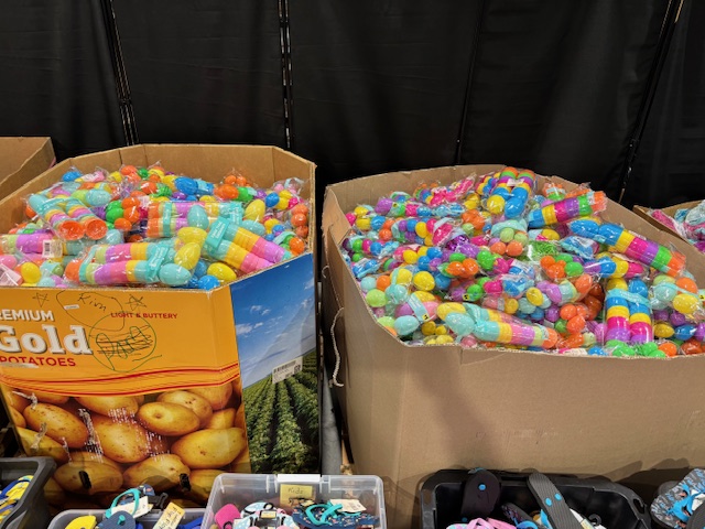 Large gaylord bins filled with colorful plastic Easter eggs and egg fillers in bulk at a liquidation warehouse.