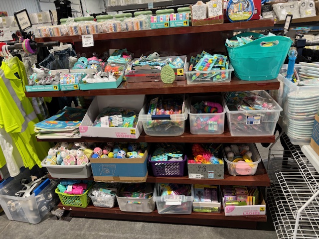 Shelves filled with assorted Easter basket fillers, toys, and decorations from liquidation inventory.