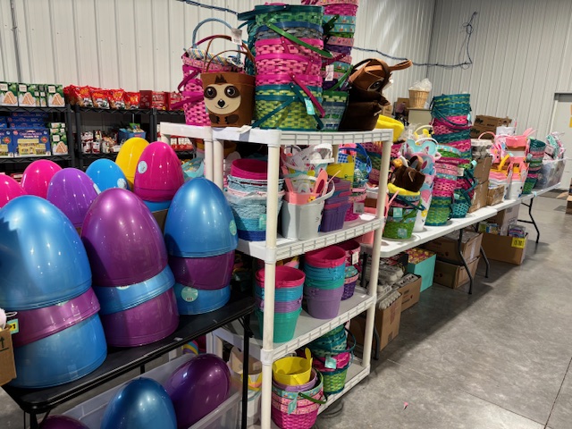 Large assortment of Easter liquidation items including plastic eggs, baskets, buckets, and decorations displayed on shelves in a liquidation warehouse.