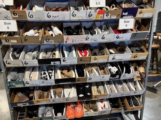 Shelves filled with size 6 women’s shoes in boxes, organized by style and color for resale or retail display