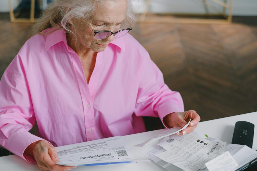Senior woman reviewing medical bills and Medicare paperwork at home