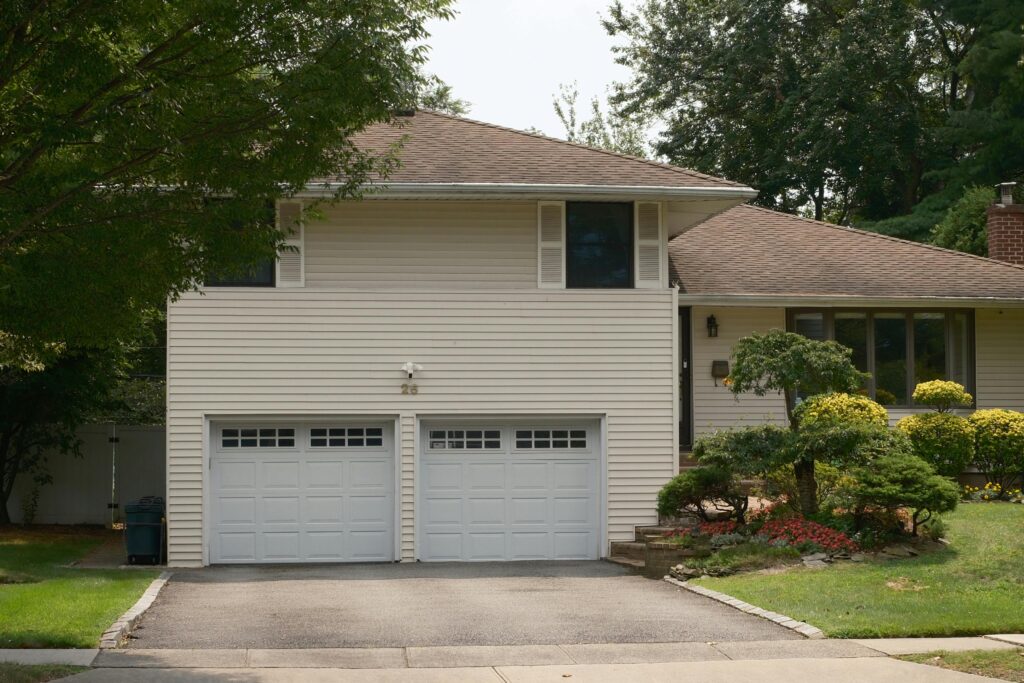 Suburban home with double garage and landscaped front yard representing homeowners insurance savings