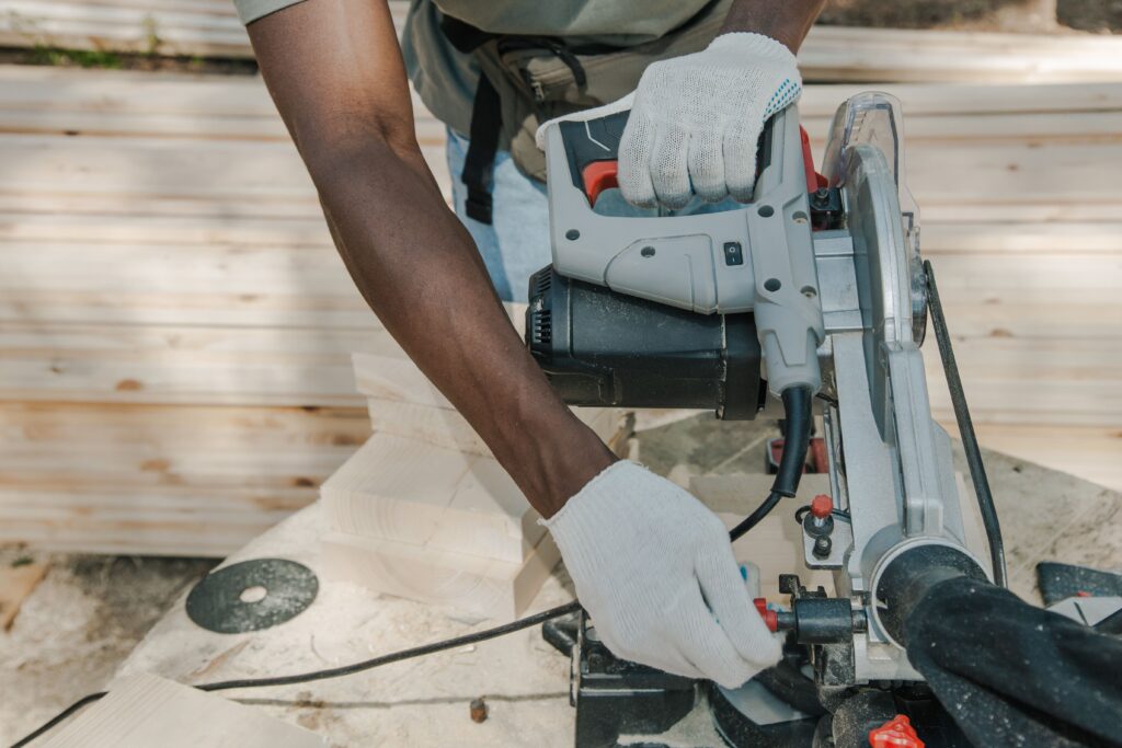 Person using a power saw while cutting lumber, representing tools you can rent out for extra income.
