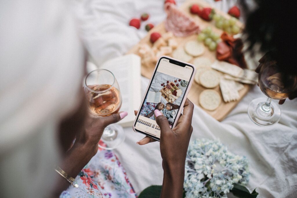 Professional using a smartphone to share content on social media while networking with others.