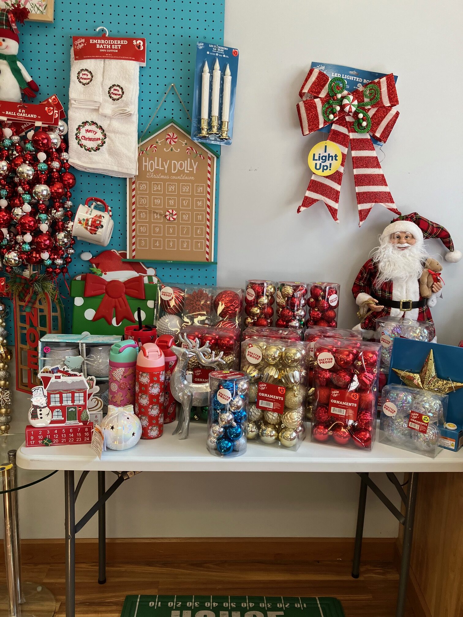 Christmas liquidation display featuring discounted ornaments, Santa decorations, holiday tumblers, Christmas lights, and festive home decor.