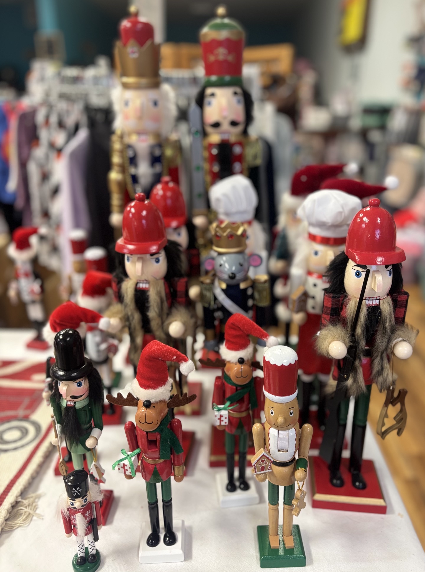 Collection of Christmas nutcracker decorations in various sizes and festive designs displayed for sale.