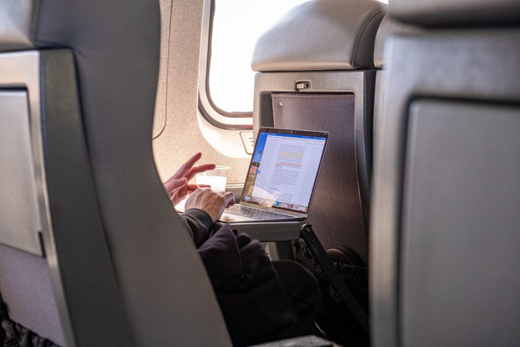 Traveler working remotely on a laptop while riding a train.